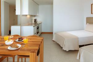 una habitación con una cama y una mesa con comida. en Parque Santiago IV Official en Playa de las Americas
