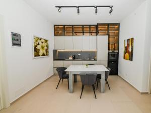 a kitchen with a table and chairs in a room at Green Cost Luxury Apt 239 in Palasë