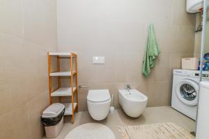 a bathroom with a toilet and a sink and a washing machine at Green Cost Luxury Apt 239 in Palasë +22 photos