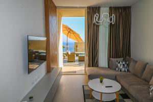 a living room with a couch and a table at Green Cost Luxury Apt 239 in Palasë