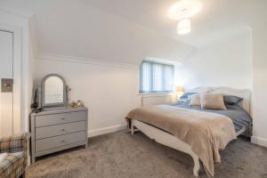 a bedroom with a bed and a dresser and a window at COSY HOME NEAR DORNEY, WINDSOR & Free Parking in Taplow
