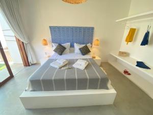 ein Schlafzimmer mit einem Bett mit blauem Kopfteil in der Unterkunft Maison dos Corais in São Miguel do Gostoso