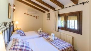 two twin beds in a room with a window at Alojamiento Rural El Aguelo Belmez de la Moraleda by Ruralidays in Jaén +28 photos