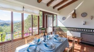 comedor con mesa y algunas ventanas en Alojamiento Rural El Aguelo Belmez de la Moraleda by Ruralidays, en Jaén