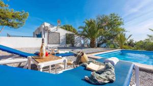 une personne allongée sur un canapé bleu à côté d'une piscine dans l'établissement Casa Andalucía Vélez-Málaga by Ruralidays, à Vélez-Málaga