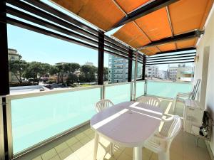 een tafel en stoelen op een balkon met uitzicht bij Albanella - Appartamenti in Bibione
