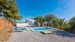 une maison avec une piscine et deux chaises longues dans l'établissement Casa Andalucía Vélez-Málaga by Ruralidays, à Vélez-Málaga