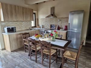 a kitchen with a table with chairs and a refrigerator at Villa Gamma Kreta in Kamilari