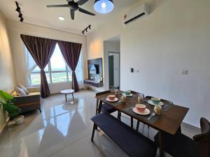 un soggiorno con tavolo da pranzo e un soggiorno con soffitto di Amber Cove Executive Suites Melaka a Malacca
