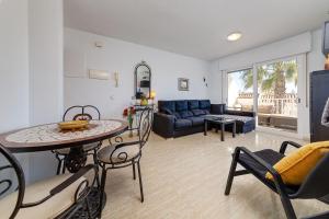 een woonkamer met een tafel, stoelen en een bank bij Aguamarina Playa in Orihuela