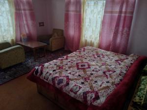 a bedroom with a bed with a quilt on it at OYO Grand Inayat in Jawāharnagar