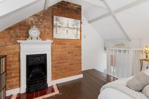 ein Schlafzimmer mit einer Ziegelwand und einem Kamin in der Unterkunft Pip's Cottage by Staytor Accommodation in Exeter