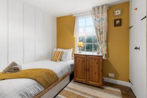 a small bedroom with two beds and a window at Pip's Cottage by Staytor Accommodation in Exeter