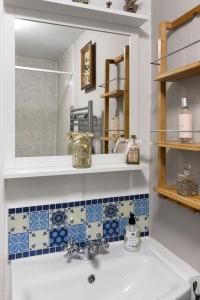 een badkamer met een wastafel en een spiegel bij Pip's Cottage by Staytor Accommodation in Exeter