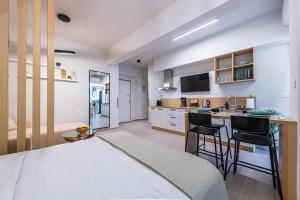 ein Schlafzimmer mit einem Bett und eine Küche mit einer Theke in der Unterkunft Feel like home in Athen