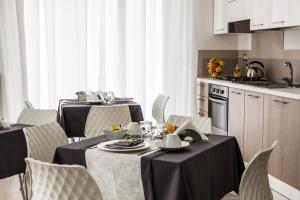 a dining room with two tables and chairs and a kitchen at B&B ARFE' in Casarano