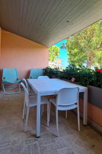 a white table and chairs sitting on a patio at Il Grecale - Piscina e Ombrellone spiaggia prima fila incluso in Marcelli