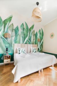 a bedroom with a large mural of leaves at Modern Apartments Piłsudskiego Street in Krakow