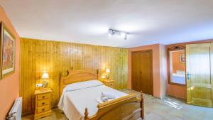 a bedroom with a bed and wooden walls at El Rincón de La Iruela by Ruralidays in La Iruela