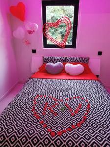 ein rosafarbenes Zimmer mit einem Bett mit Herz darauf in der Unterkunft Détente assurée dans ce logement avec balnéo in Rezé