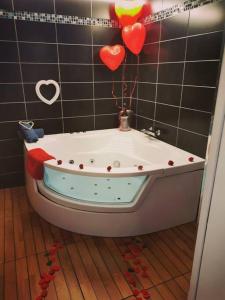 a bath tub in a bathroom with hearts on the wall at Détente assurée dans ce logement avec balnéo in Rezé