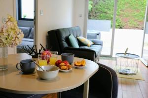 a table with a plate of fruit and drinks on it at Détente assurée dans ce logement avec balnéo in Rezé