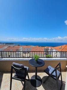 a table and chairs on a balcony with a view of the ocean at Apartments Adriatika in Makarska