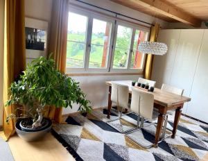 ein Esszimmer mit einem Tisch und einer Topfpflanze in der Unterkunft Doppelzimmer in charmantem B&B in Hemberg