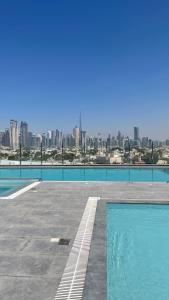 a swimming pool with a city skyline in the background at Al Khoory Courtyard Hotel in Dubai