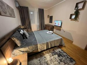 Un dormitorio con una cama y un televisor. en Център Варна апартамент с паркинг за нормална до средно голяма кола, en Varna