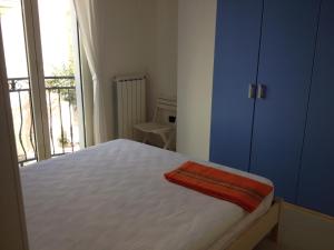 a bedroom with a white bed and a large window at Bianco&Nero 61 Apartament in Margherita di Savoia