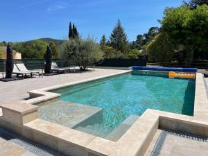 una piscina con acqua blu in un cortile di Domaine de Calypso & Suites - Adult Only ad Auriol