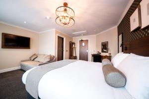 a bedroom with a large white bed and a couch at Miller & Carter Sheffield by Innkeeper's Collection in Sheffield