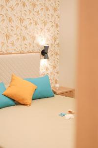 a bedroom with a bed with blue and orange pillows at Don Francisco Rooms - TROPEA in Tropea