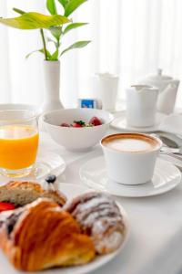 una mesa con platos de comida y una taza de café en Aura Living Hotel, en Rímini