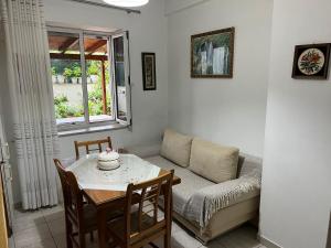 a living room with a table and a couch at Goni Guest House in Sarandë