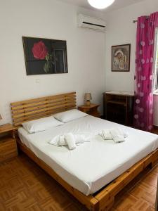 a bedroom with a large bed with two white towels on it at Goni Guest House in Sarandë