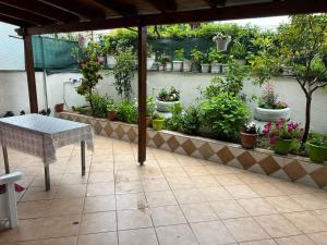 a patio with a table and potted plants at Goni Guest House in Sarandë