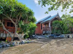 una casa con palmeras delante en Hello Sichang Bungalow en Ko Si Chang