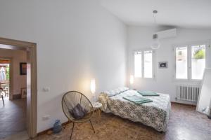 1 dormitorio con 1 cama y 1 silla en Ca' de la Gondola, Murano, en Venecia