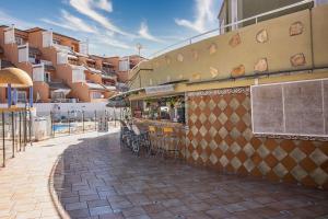a restaurant with chairs and a bar on a building at Orlando - Sea View Apartment in Costa Adeje in Adeje