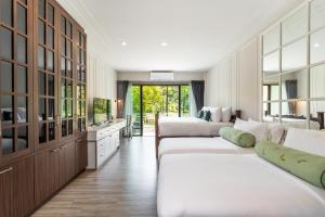 Tha Lane Bay的住宿－Blu Monkey Pooltara Krabi Hotel & Villas Pet Friendly，一间带两张床的卧室和一间带水槽的厨房