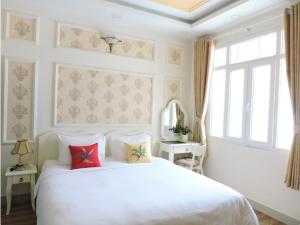 1 dormitorio con cama blanca y ventana en CHEZ LOTUS VN, en Ho Chi Minh