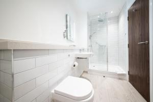 a white bathroom with a toilet and a shower at Miller & Carter Sheffield by Innkeeper's Collection in Sheffield
