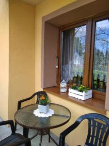 mesa y sillas en una habitación con ventana en Apartament nad szumiącym potokiem en Wilkowice