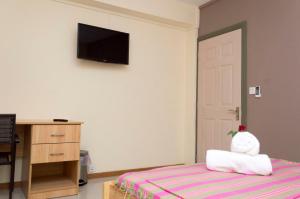 1 dormitorio con 1 cama y TV en la pared en Vintage Lodge en Quatre Bornes