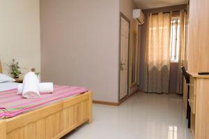 um quarto com uma cama com lençóis cor-de-rosa e brancos em Vintage Lodge em Quatre Bornes