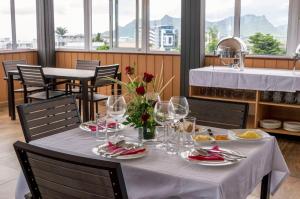 una mesa con copas de vino y flores. en Vintage Lodge en Quatre Bornes