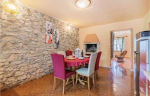 a dining room with a stone wall and a table and chairs at Beautiful Home In Pula With Wifi in Pula