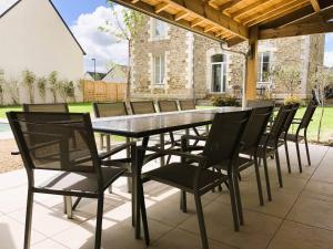 een zwarte eettafel en stoelen op een patio bij Manoir de la Fontaine Saint-Jean in Crossac